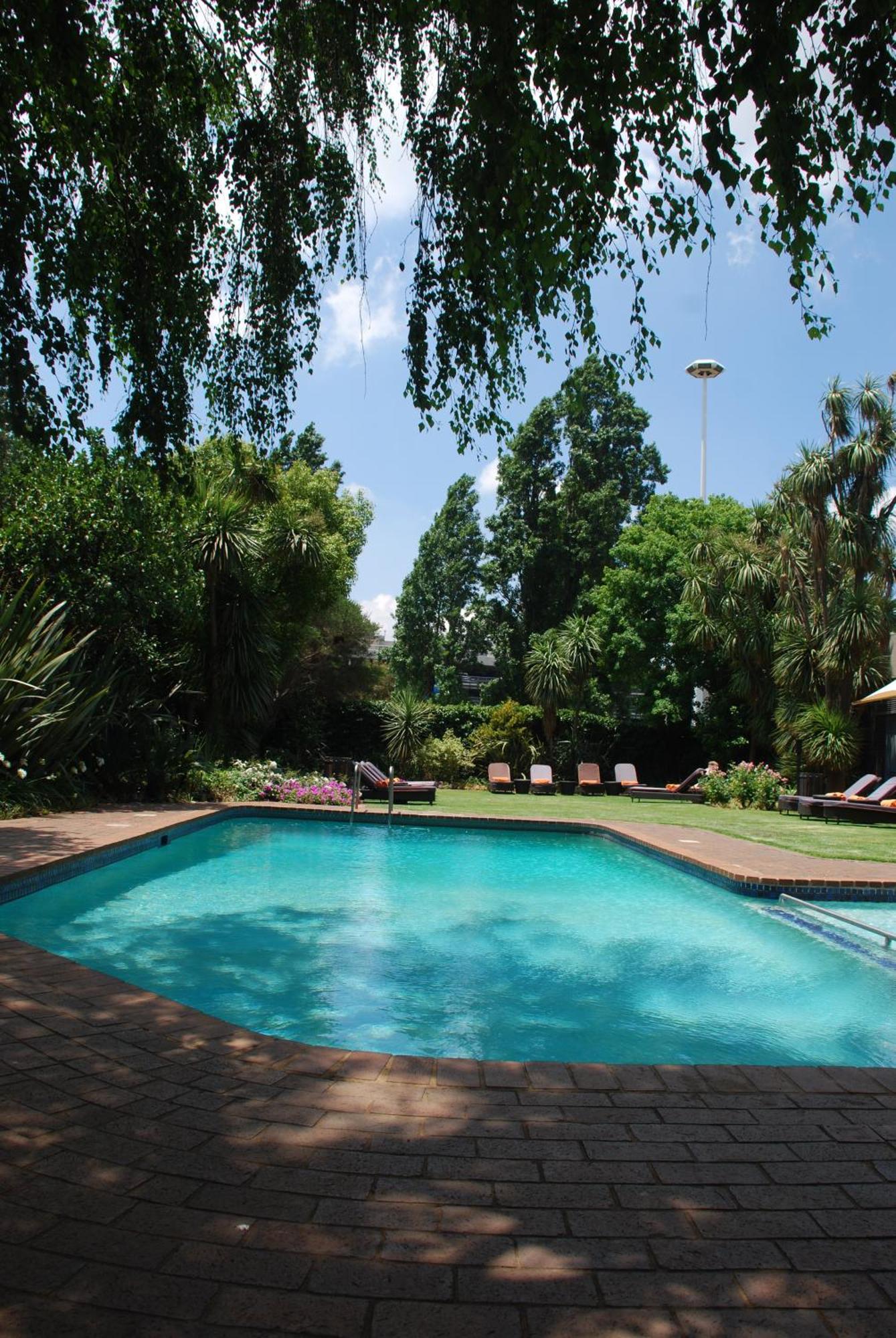 Southern Sun Or Tambo International Airport Kempton Park Exterior foto The garden and swimming pool at the residence